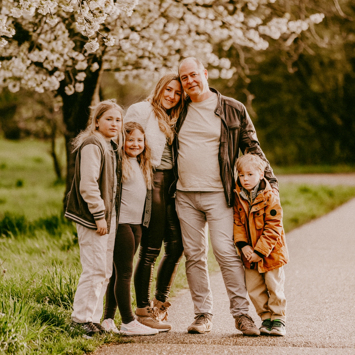 Familie mit drei Kindern beim Foto-Shooting unter Kirschbäumen