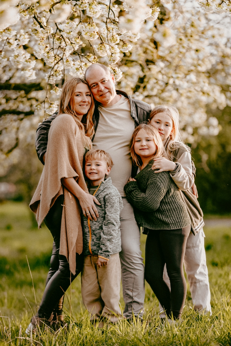 Familie mit Tochter und Sohn unter Kirschblüten beim Foto-Shooting