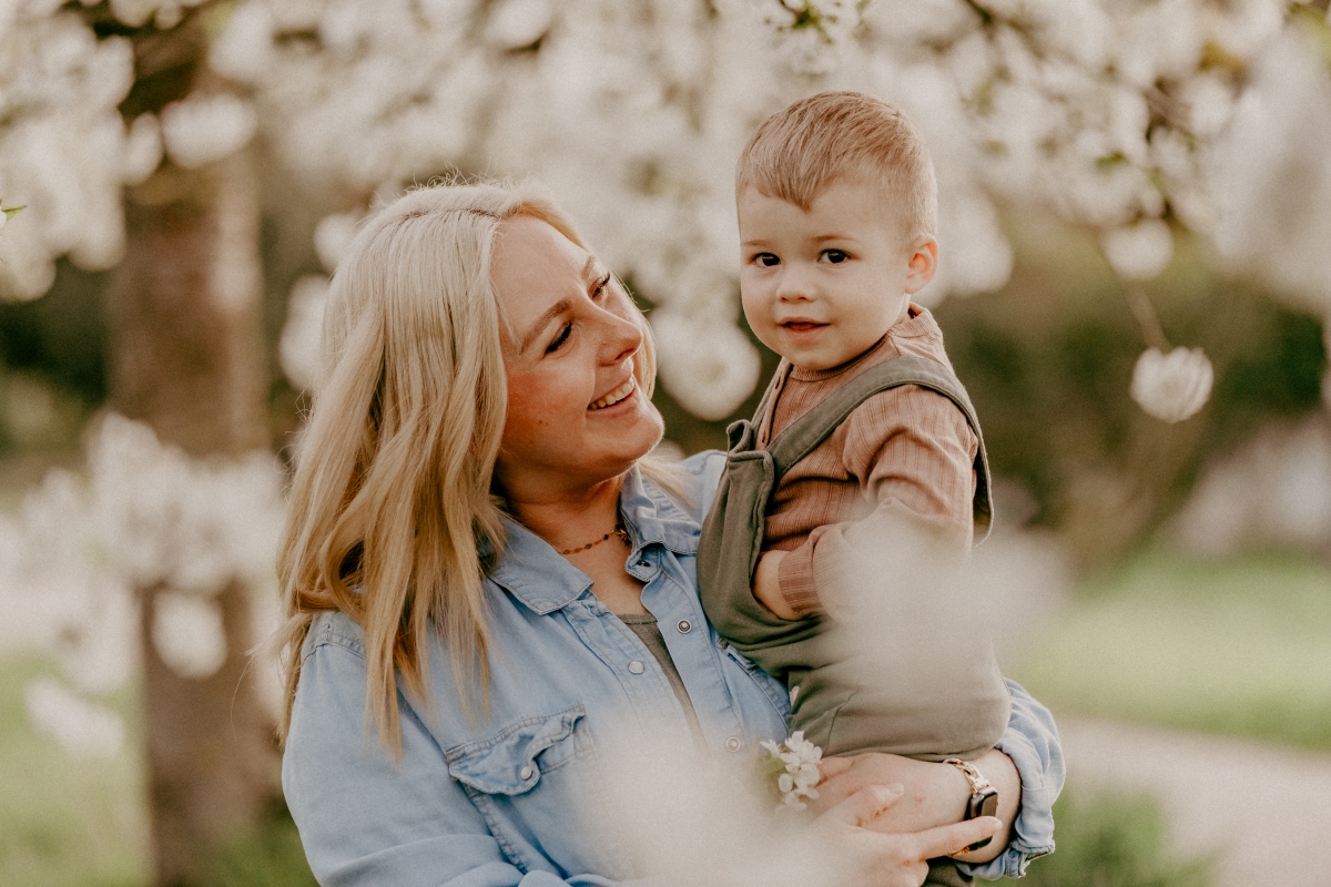 Mama und Sohn unter Kirschblüten beim Familien-Fotoshooting