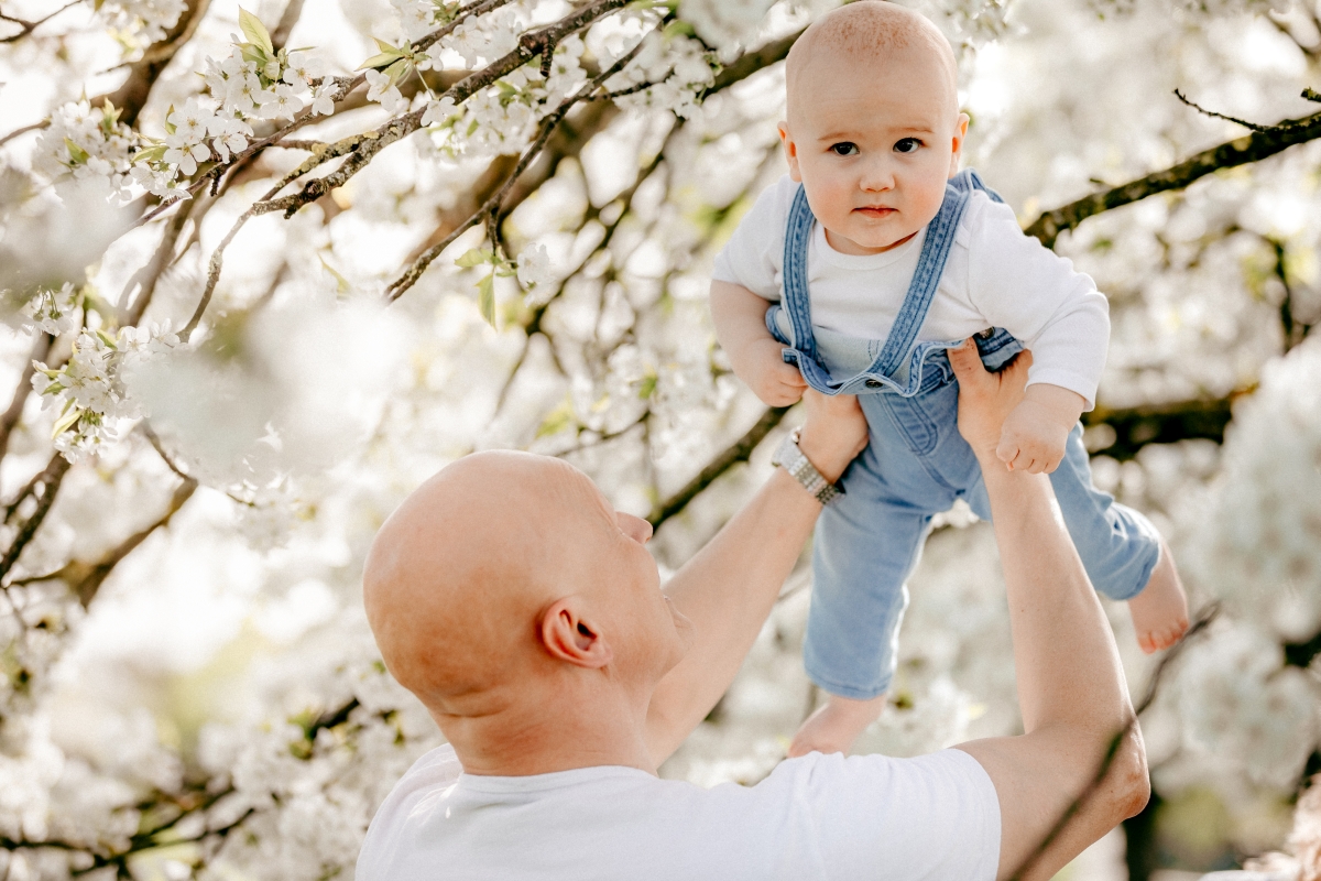 Familie mit Baby im Frühling unter Kirschblüten beim Familien-Fotoshooting