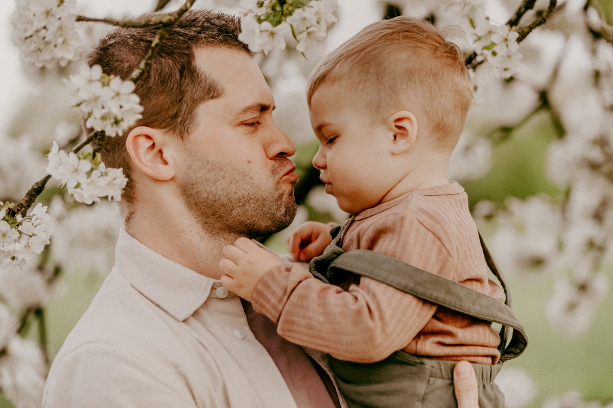 Papa und Sohn unter Kirschblüten beim Familien-Fotoshooting