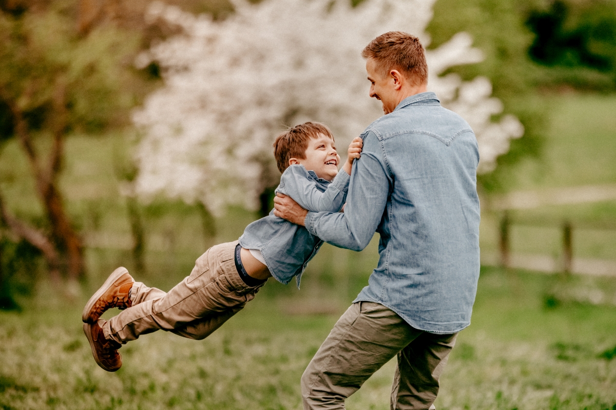 Vater und Sohn auf Frühlingswiese beim Familien-Fotoshooting