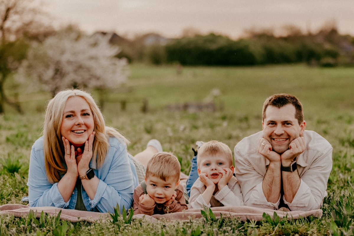 Familie lachend auf der Sommerwiese beim Familien-Fotoshooting