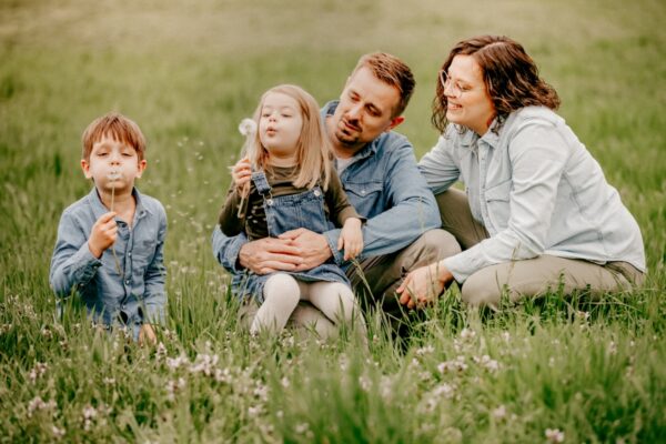Familie mit Pusteblume auf Frühlingswiese beim Familien-Fotoshooting