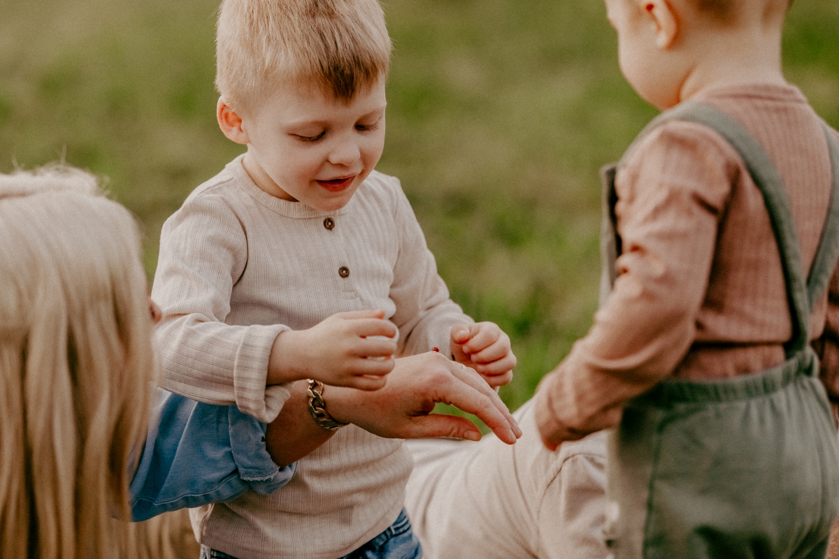 Kinder mit Marienkäfer auf der Sommerwiese beim Familien-Fotoshooting