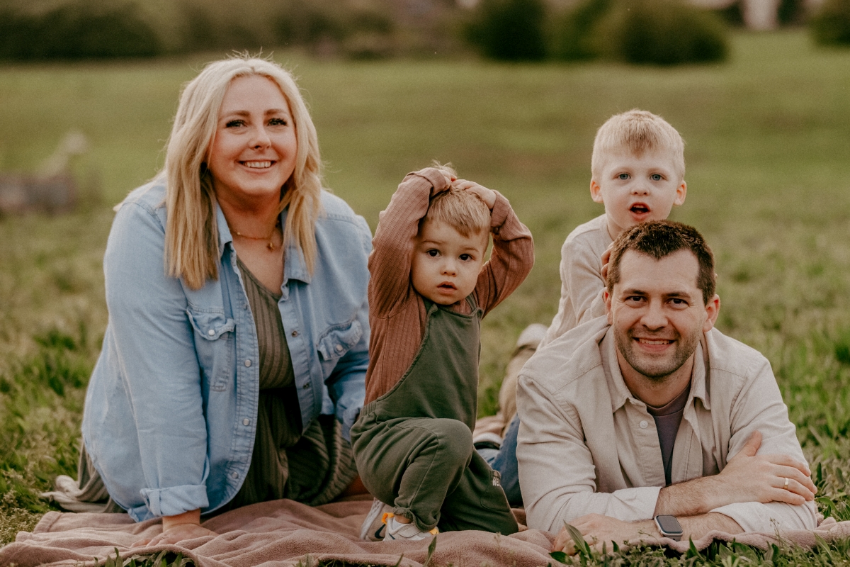 Familie lachend auf der Sommerwiese beim Familien-Fotoshooting