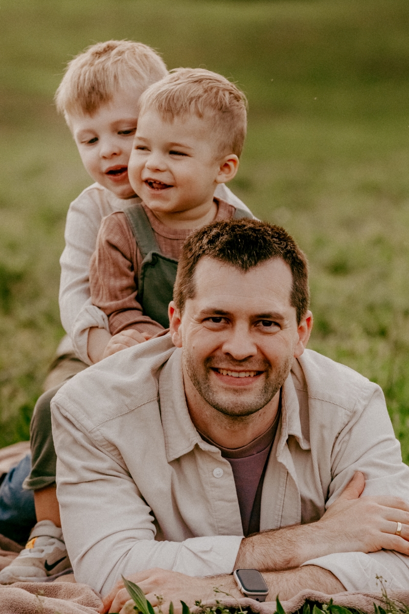 Papa mit Söhnen auf der Sommerwiese beim Familien-Fotoshooting