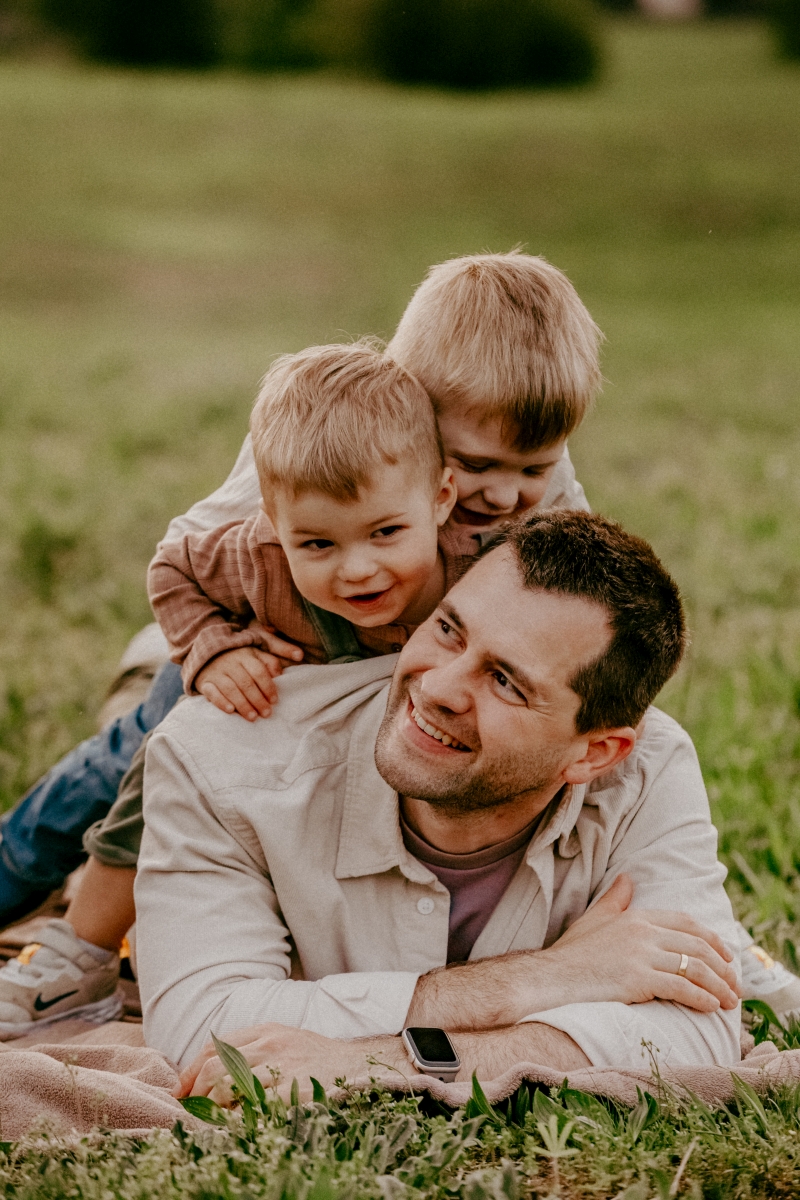 Papa mit Söhnen auf der Sommerwiese beim Familien-Fotoshooting