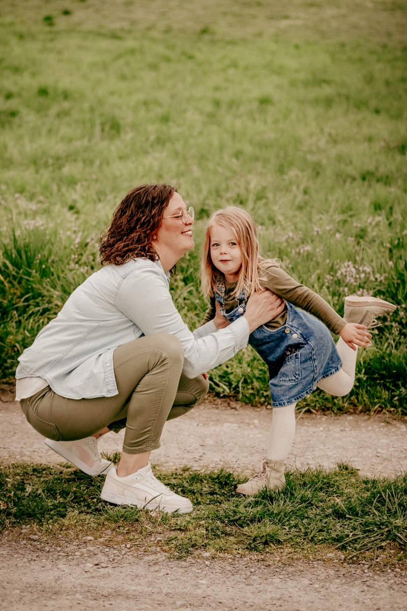 Mama und Tochter auf Frühlingswiese beim Familien-Fotoshooting