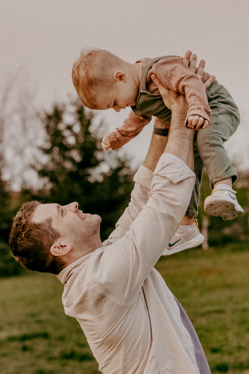Papa und Sohn auf der Sommerwiese beim Familien-Fotoshooting
